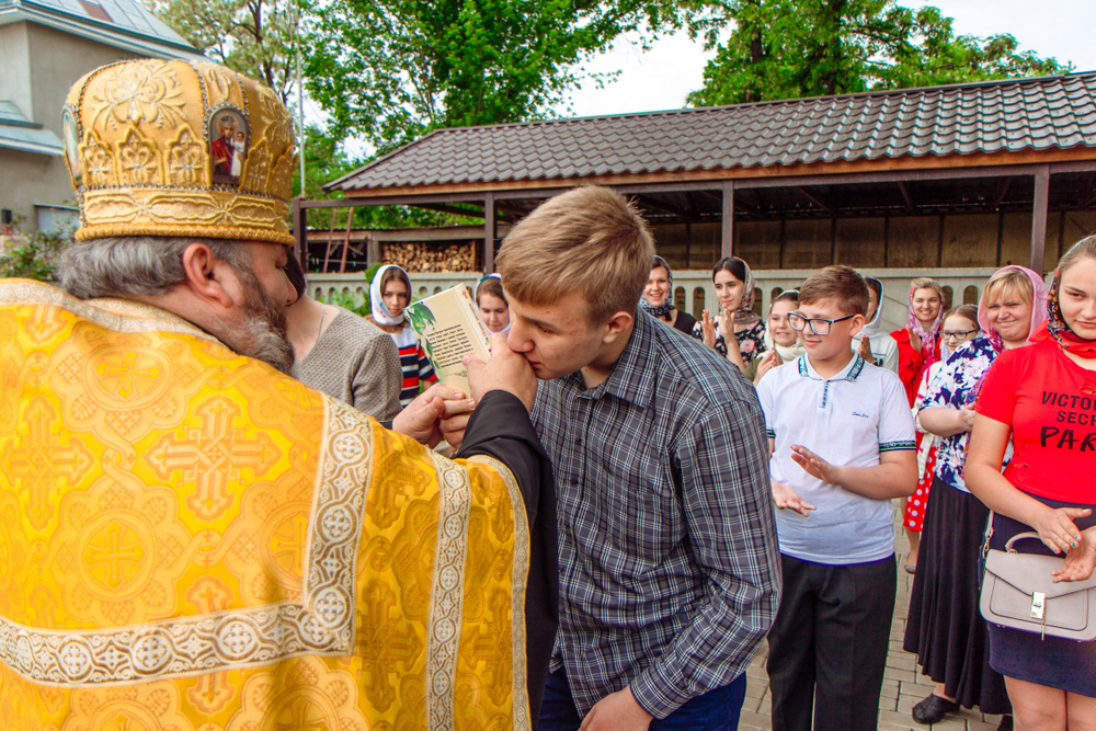 священник вручает грамоту ребенку